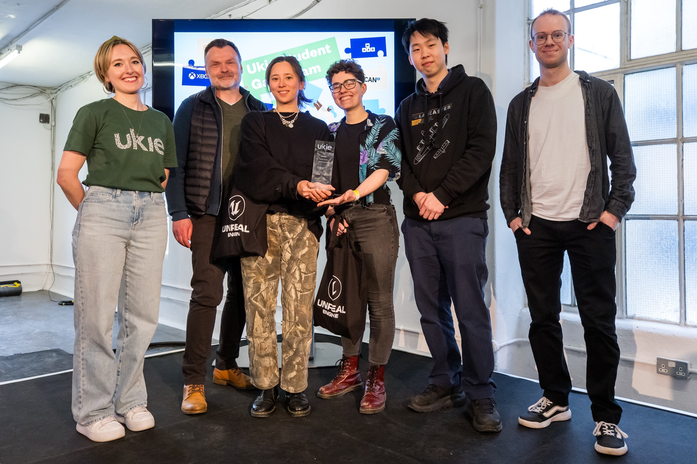 Ukie Student Game Jam Awards presentation at WASD, April 2024. Left to right: Siân (Ukie), André (Head of Games, NFTS), Ilena, Carrie, Chester and Robin (Playground Games)